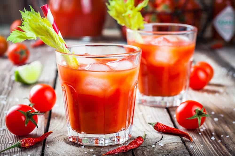 Bloody Mary cocktails in clear glasses with celery stalks