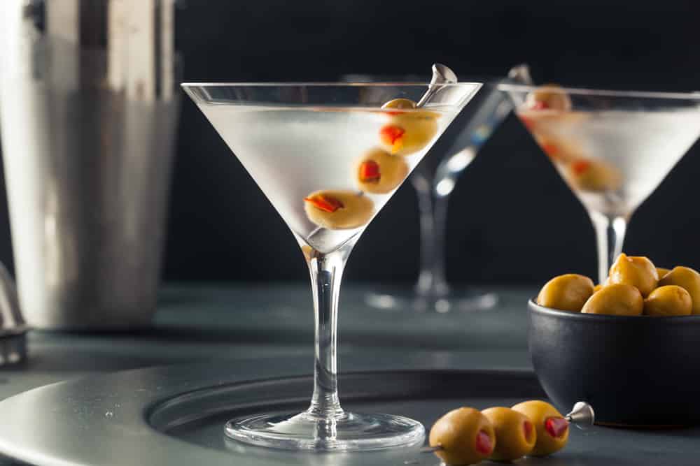 Classic shaken dry vodka martinis garnished with olive skewers