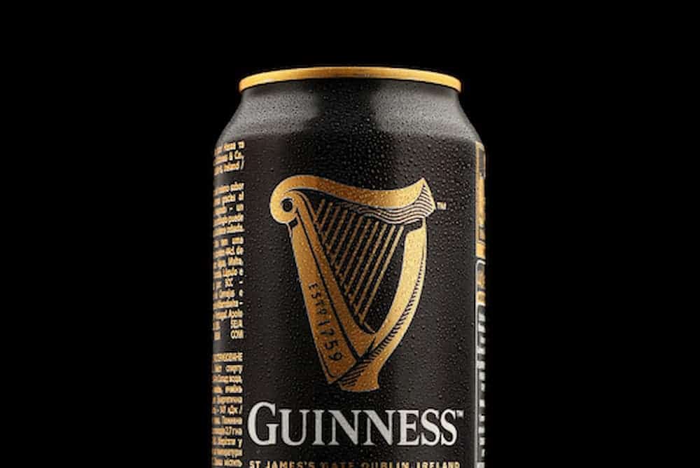 Cold can of Guinness beer with condensation on black background