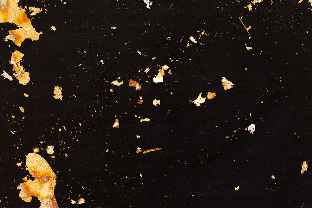 Edible flakes of gold on black background