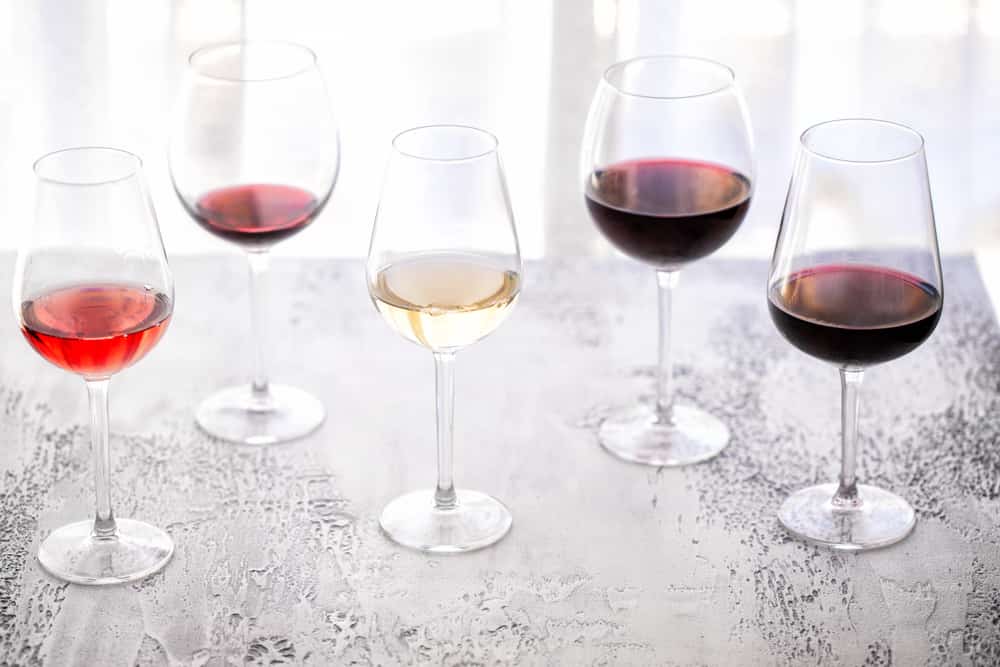 Glasses of different types of wine on metal table