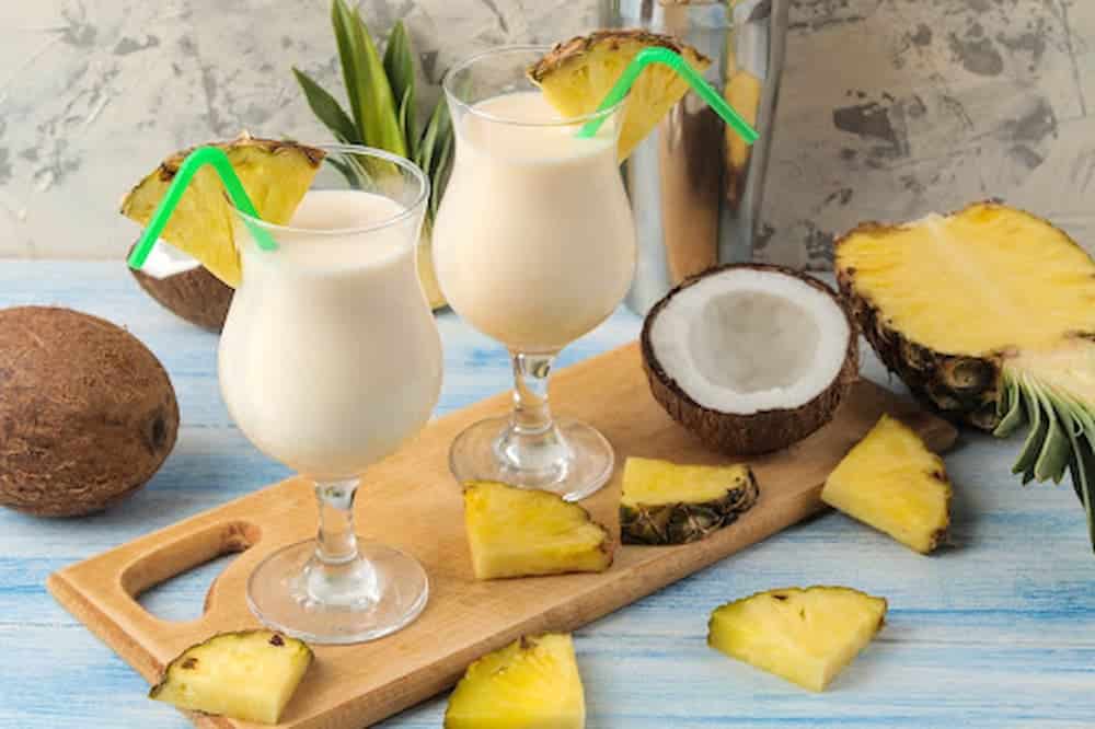 Refreshing pina colada drinks with coconut and pineapple slices