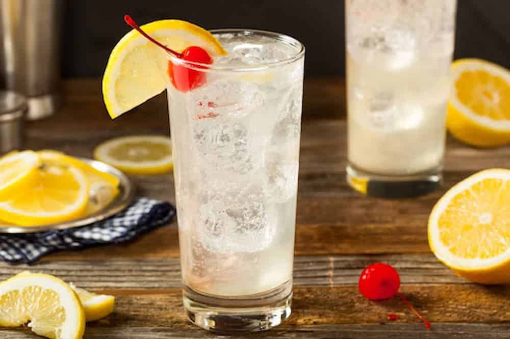 Tom Collins classic cocktail with cherry and orange garnishes